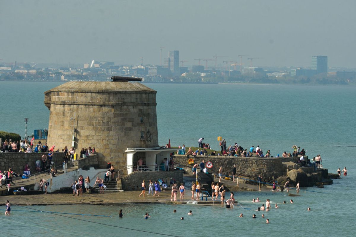 People enjoy nice sunny weather near Seapoint Beach, in Dublin
