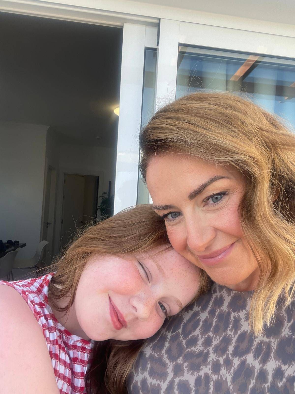 Ann cuddling her daughter Georgia on a balcony on holiday