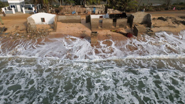 Waves lap the beach where remains of Afeli Bernice Adzo's family home stand after it was destroyed by coastal erosion in Avegadzi, Ghana, March 5, 2025 (AP Photo/Misper Apawu, File)