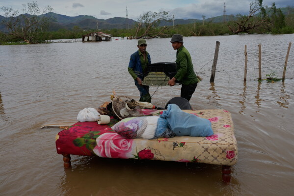 People recover belongings from a home flooded by Hurricane Melissa in Santiago de Cuba, Oct. 29, 2025. (AP Photo/Ramón Espinosa, File)
