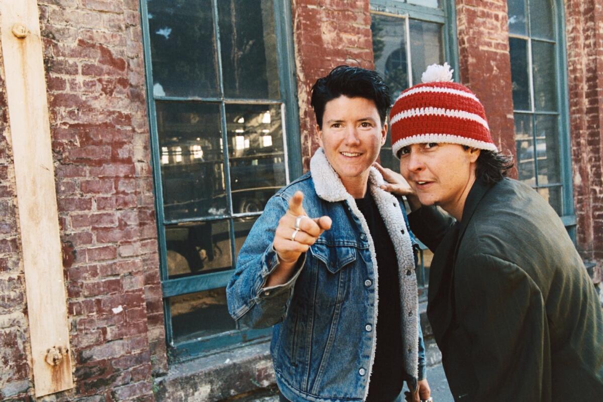 Two people smile and point outside.