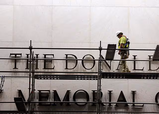 Workers erect scaffolding in front of the John F. Kennedy Centre