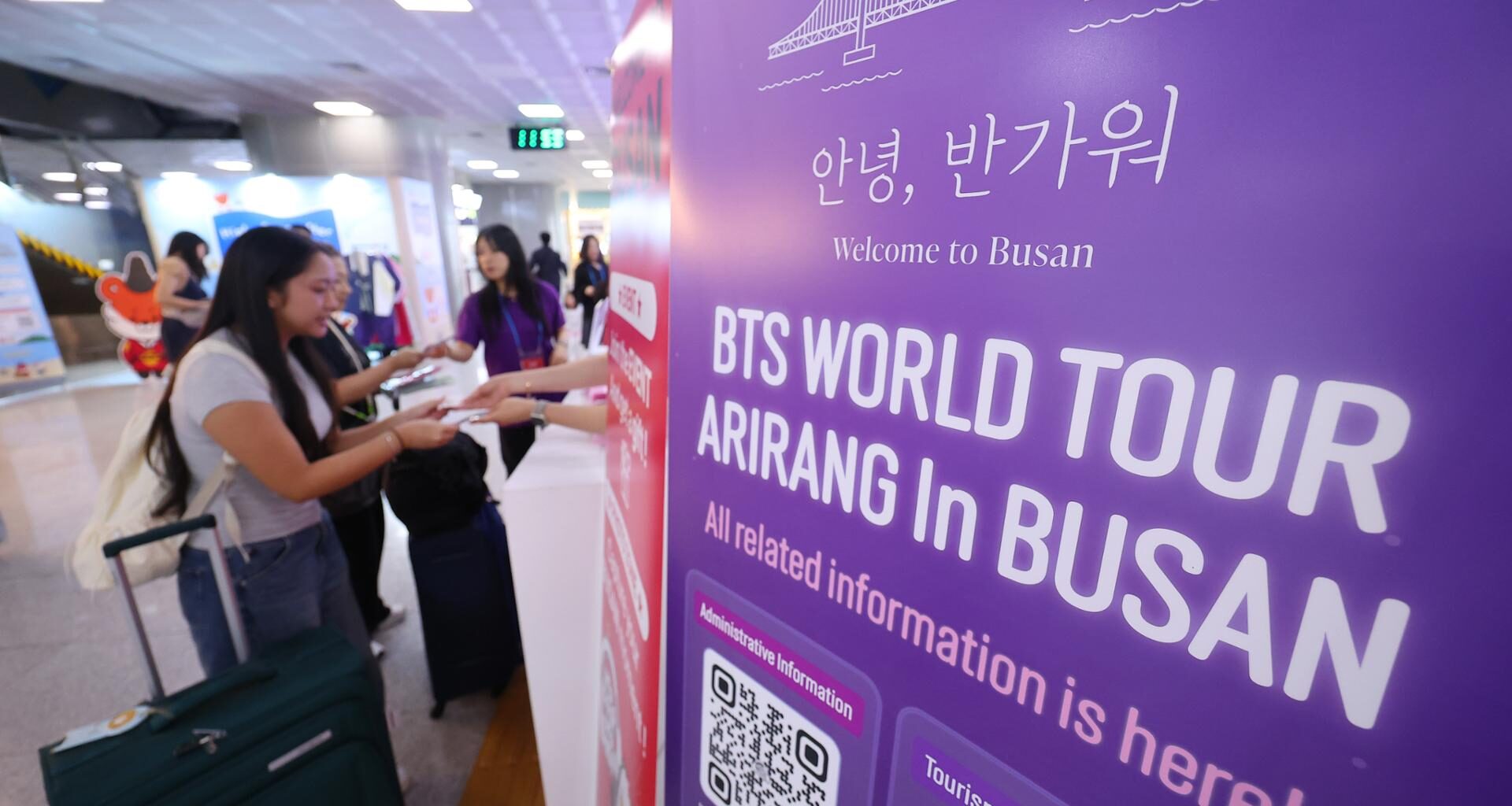 BTS fans from around the world receive souvenirs at a welcome booth set up by the Busan Tourism Organization in the international arrivals hall of Gimhae International Airport in Busan, June 10. Yonhap