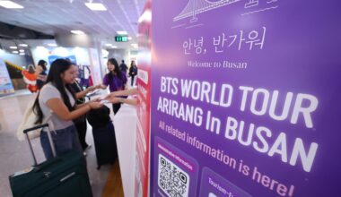 BTS fans from around the world receive souvenirs at a welcome booth set up by the Busan Tourism Organization in the international arrivals hall of Gimhae International Airport in Busan, June 10. Yonhap