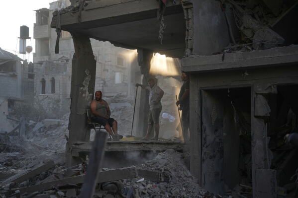 Palestinians clear the rubble of a building that was destroyed in an Israeli airstrike, at al-Maghazi refugee camp, central Gaza Strip, Friday, June 12, 2026. (AP Photo/Abdel Kareem Hana)