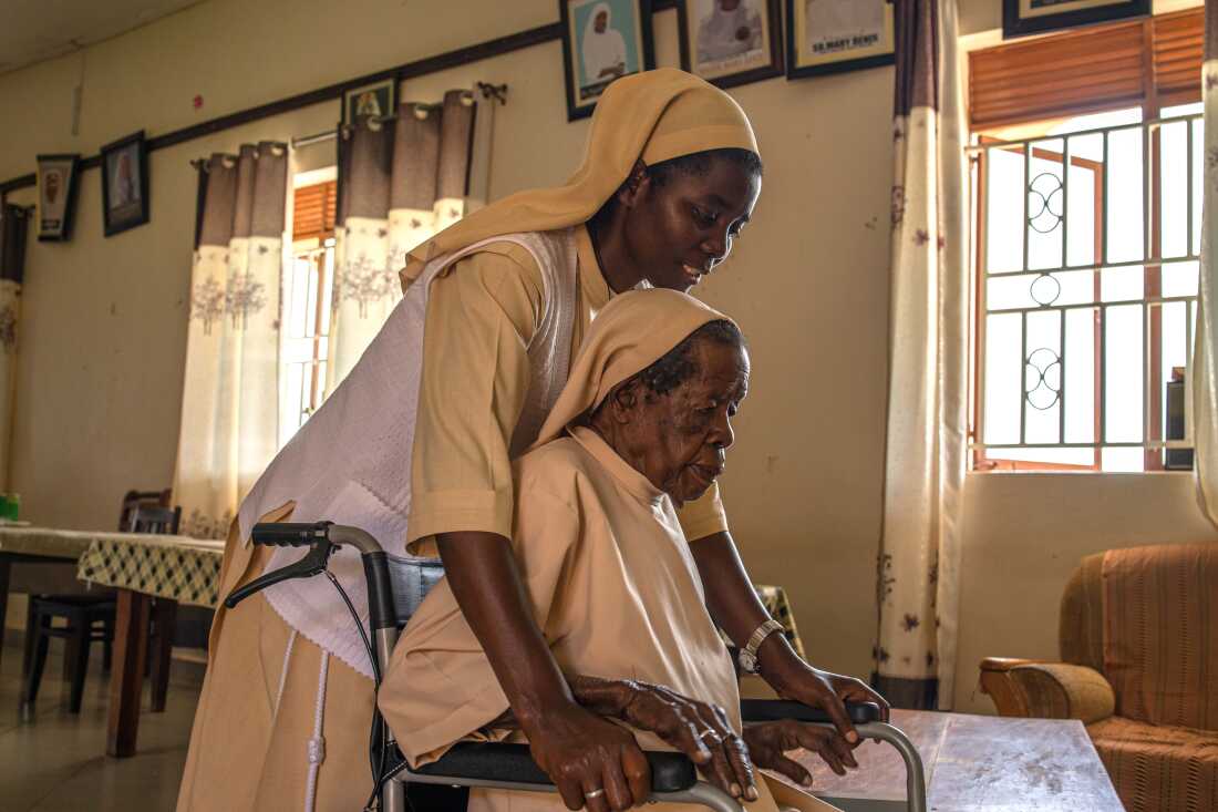 Sister Mary Consolata Nakawoojwa wheels an elderly nun to her room at the Little Sisters of St. Francis premises in Nkokonjeru, Uganda on May 12, 2026.