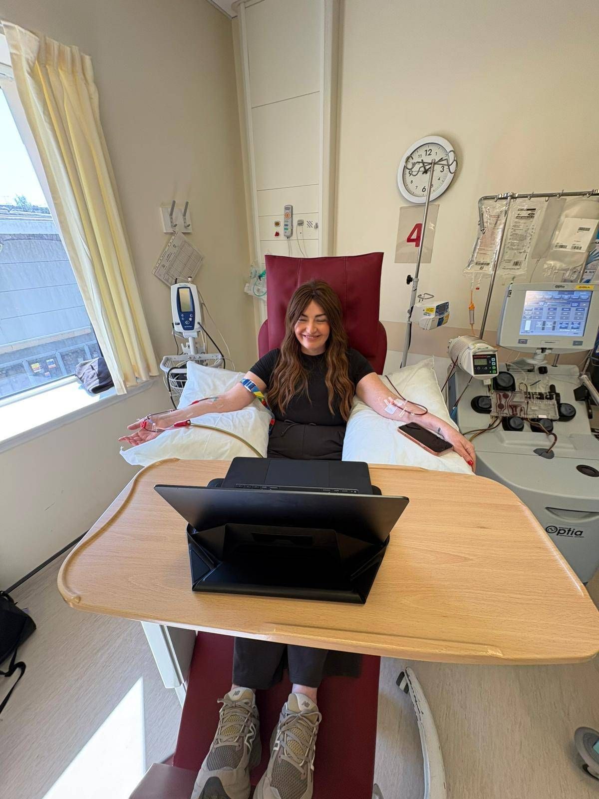 Ann in hospital bed receiving treatment dressed all in black