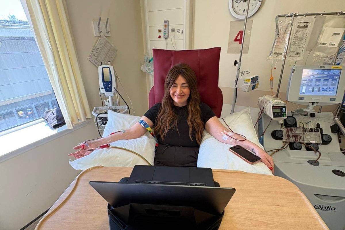 Ann in hospital bed receiving treatment dressed all in black
