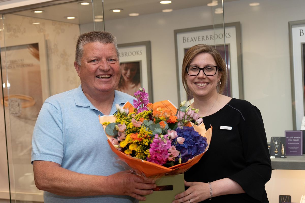 Undated handout photo issued by allwyn of Gary MacDonald, who quit his job after scooping £5.2 million on the lottery, with Katie Feeney, during his visit to his former workplace