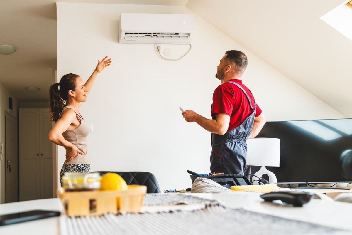 Man field technician and the female client are checking the domestic AC