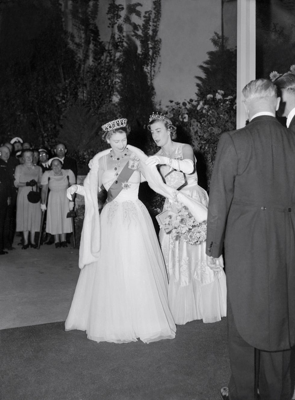 Lady Pamela Mountbatten, right, lady-in-waiting, adjusts Queen Elizabeth's stole at the Roya