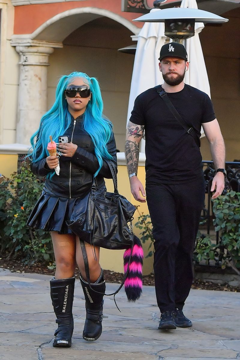 The 12-year-old turned a casual outing into a fashion moment with chunky motocross boots, a pleated mini skirt, and her signature blue hair.