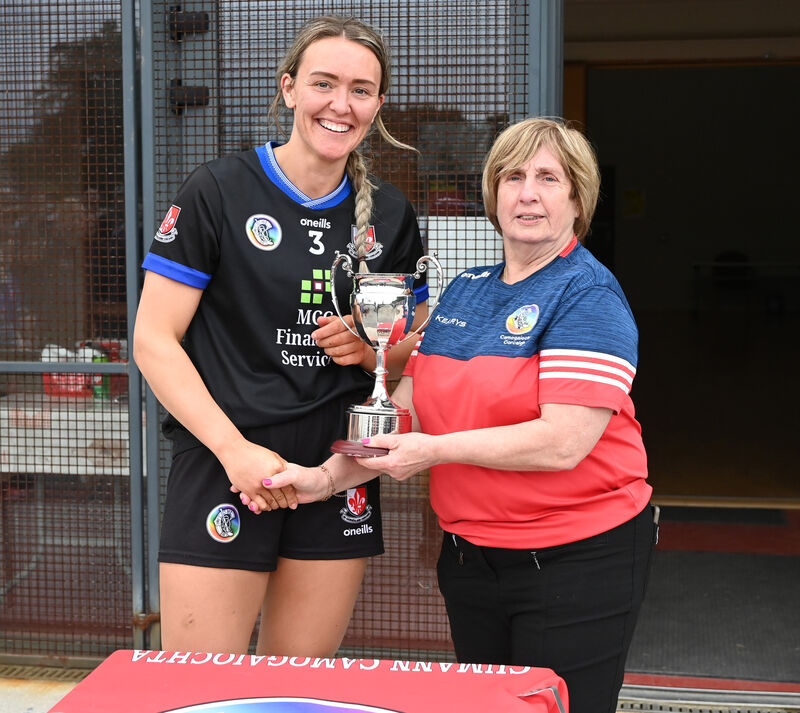 Mary McSweeney presents the trophy to Sarsfields captain Katie Barry. Picture: Eddie O'Hare
