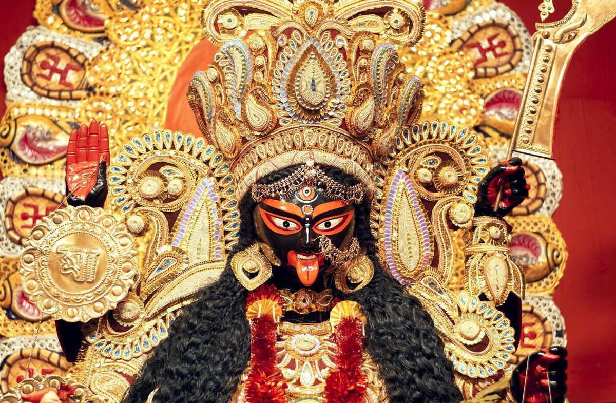Portrait of Hindu Goddess Kali, heavily decorated with golden ornaments and zari (golden embroidery) works.