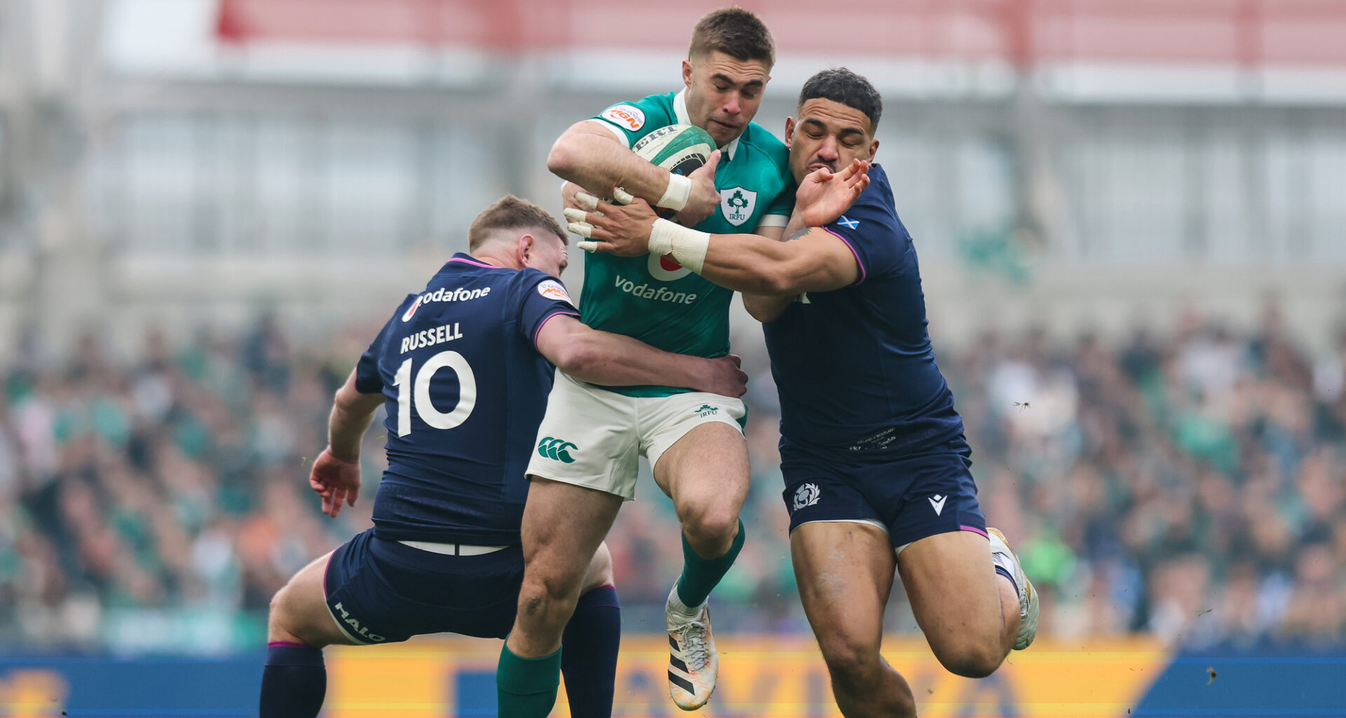 Ireland's Jack Crowley is tackled by Scotland's Sione Tuipulotu and Finn Russell. Pic: Ryan Byrne/Inpho