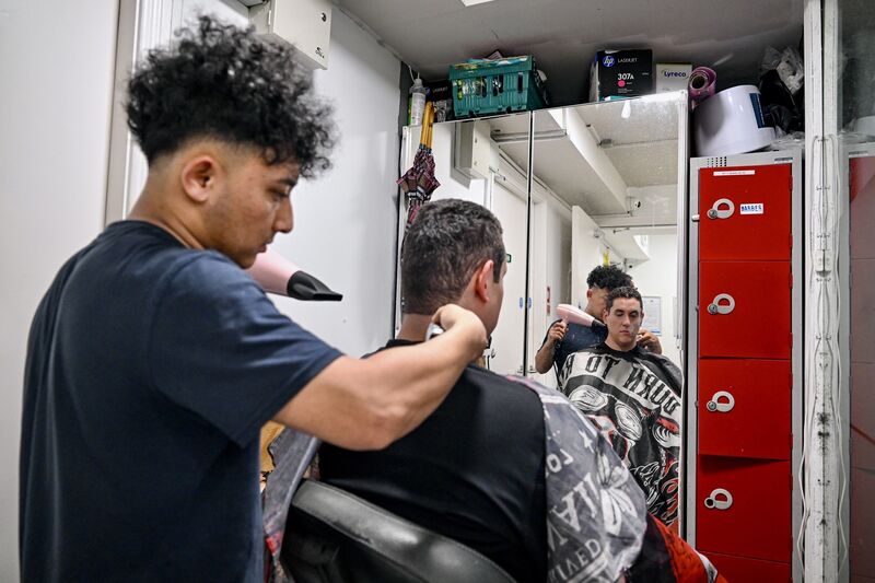 A volunteer gives a service user a haircut.