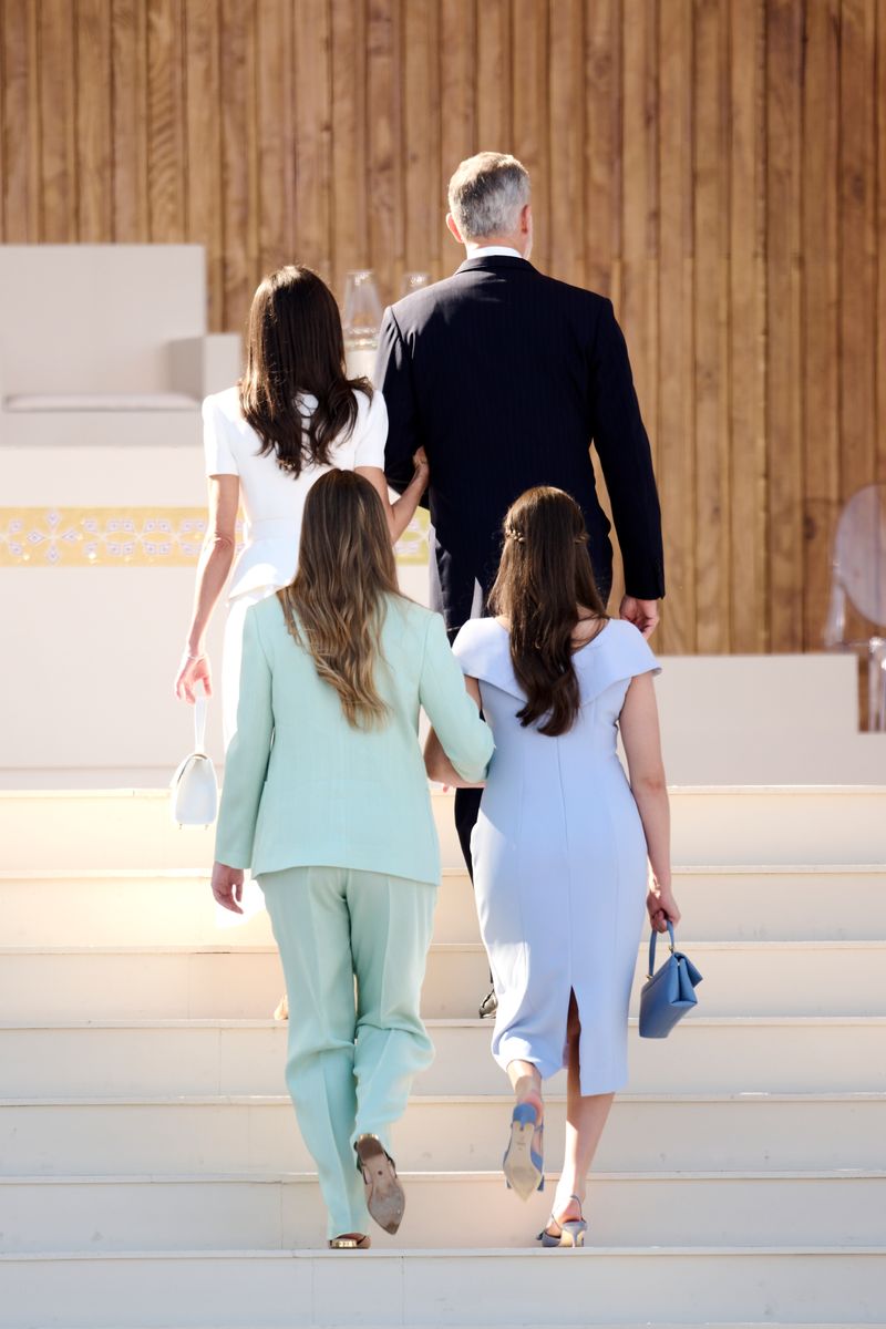 Leonor and Sofía seen in a moment of quiet connection amid official ceremonial proceedings.