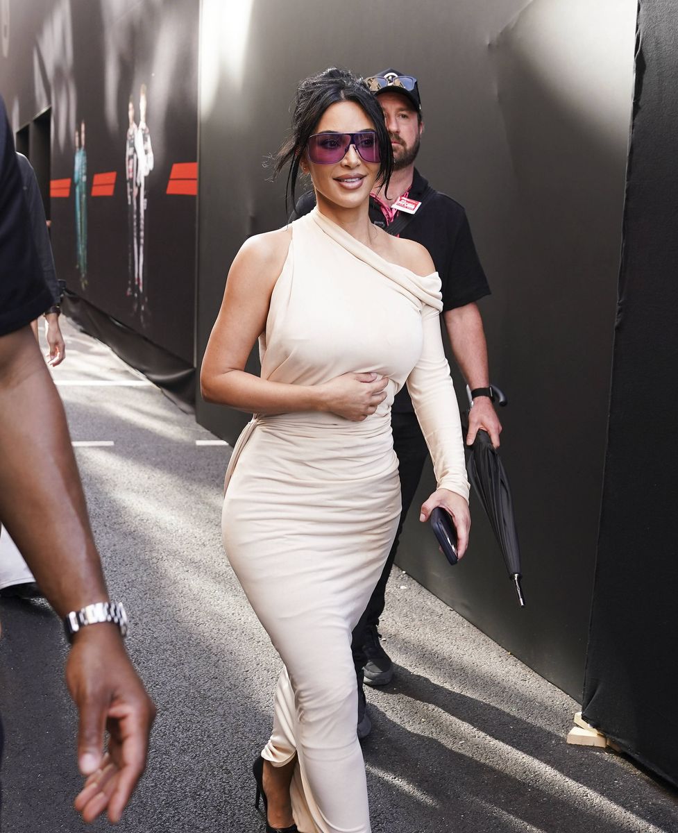 The SKIMS founder paired the neutral-toned dress with a loose updo, face-framing tendrils and oversized purple-tinted sunglasses.