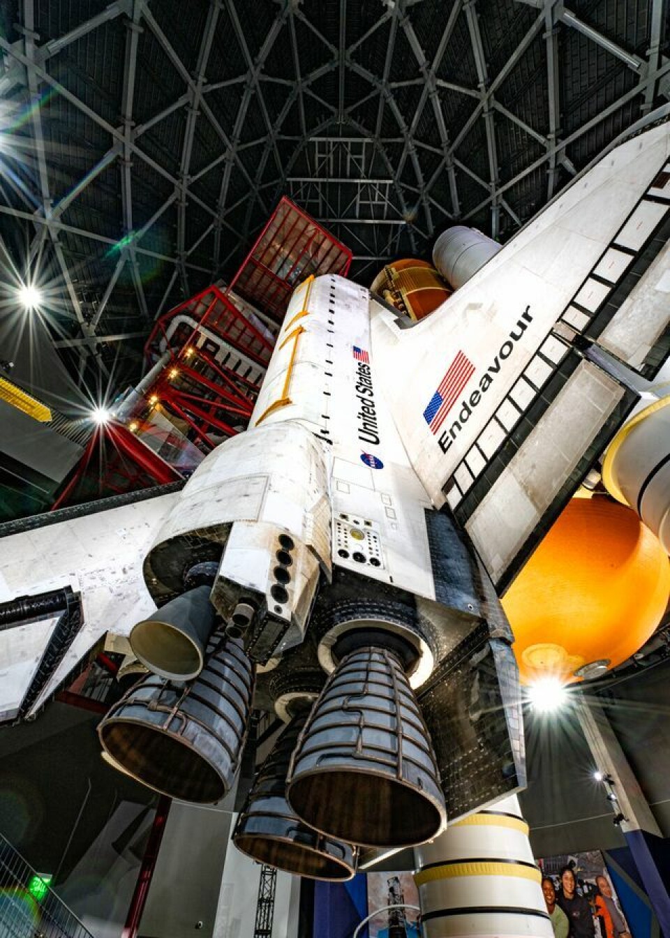 Space shuttle displayed vertically inside a domed exhibition hall.