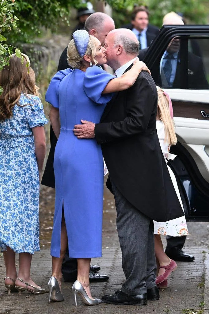 Zara Tindall hugging a family member wearing a blue dress and heels