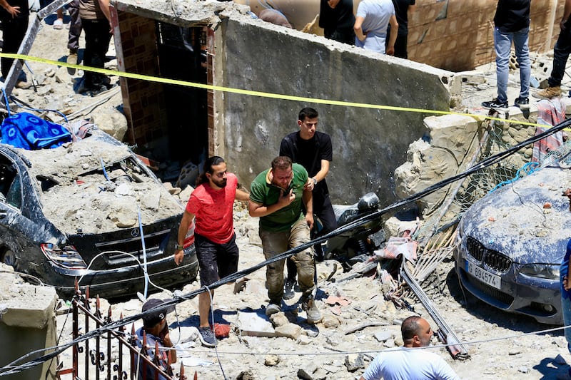 Lebanese rescuers help a man at the site of an Israeli airstrike on the town of Qannarit, Sidon district, southern Lebanon, on Saturday. Photograph: Stringer/EPA