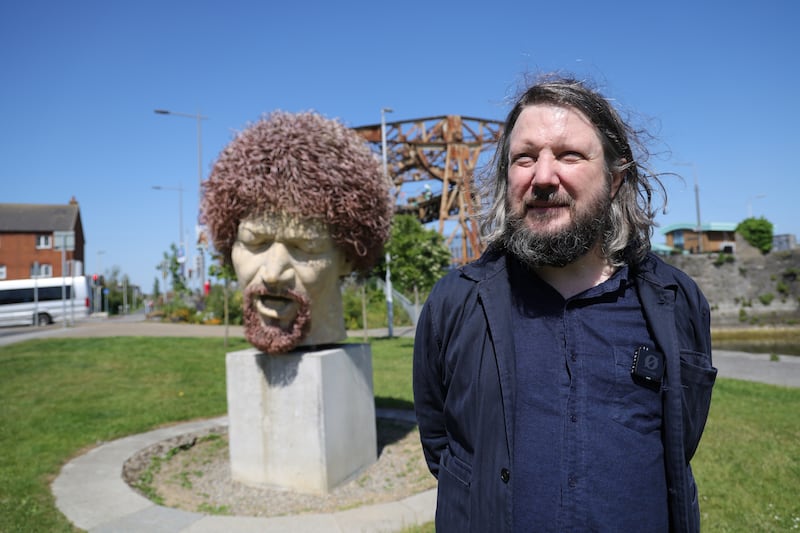Patrick Freyne at the statue of Luke Kelly in Dublin's Docklands which  he references in his new book Experts in a Dying Field. Photograph: Bryan O’Brien/The Irish Times
