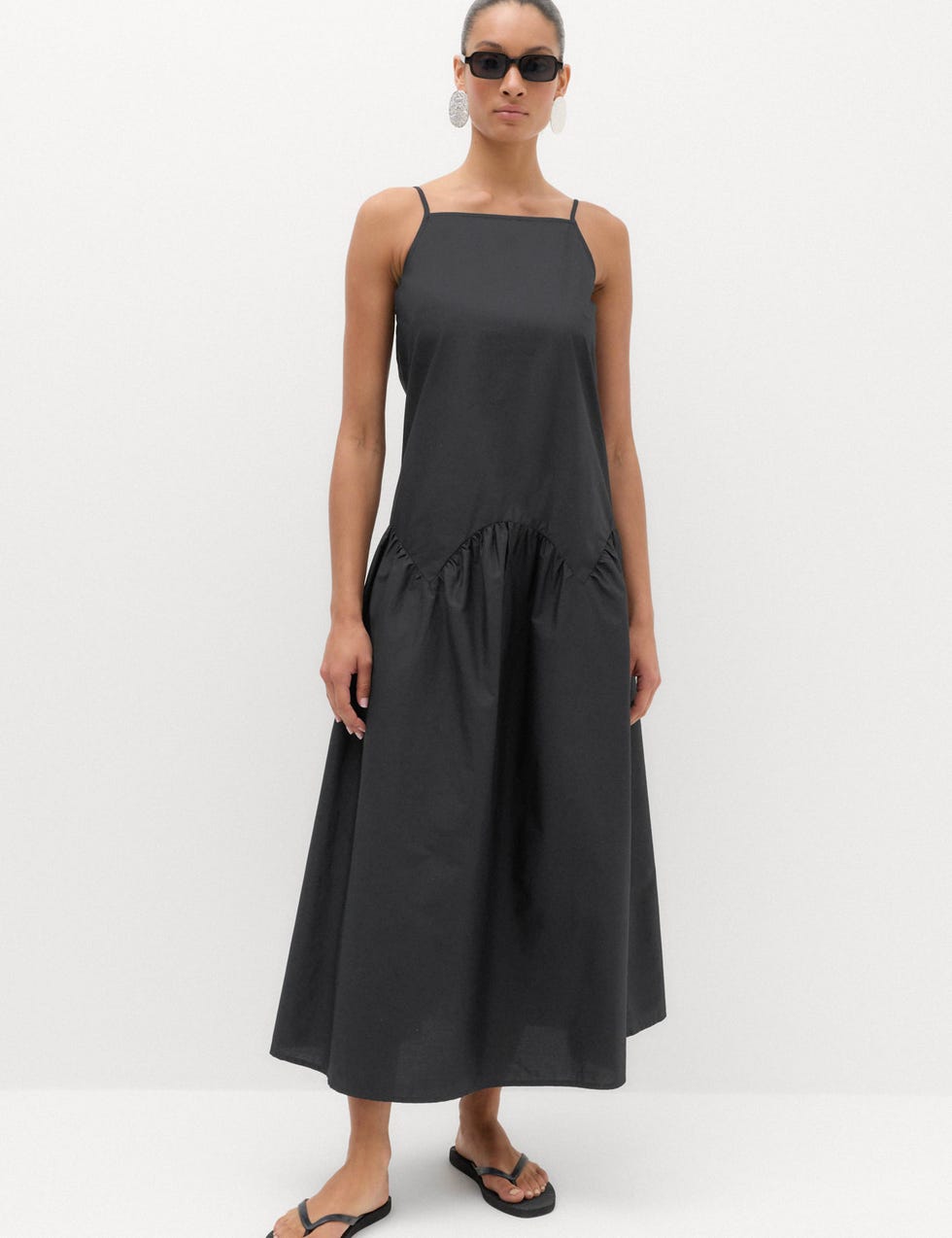 Model wearing a black dress and flip flops model wearing a black dress and flip flops