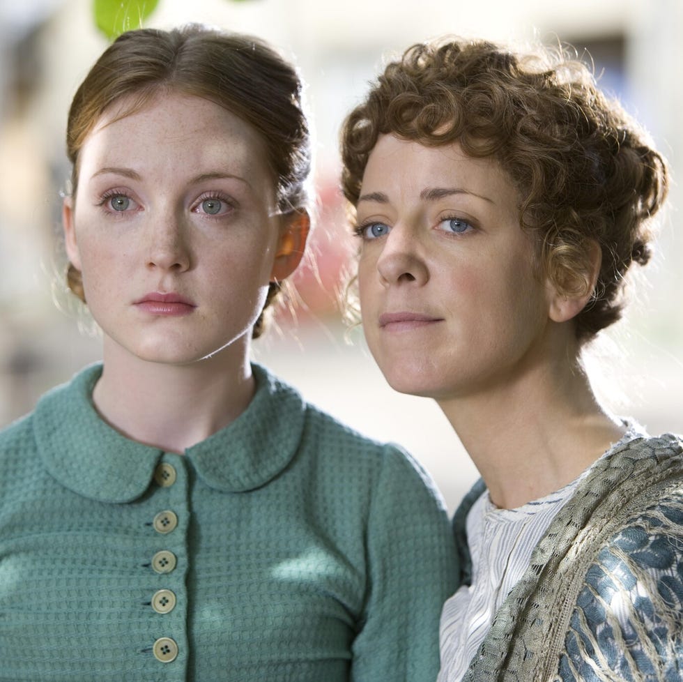two women standing closely together with faces obscured