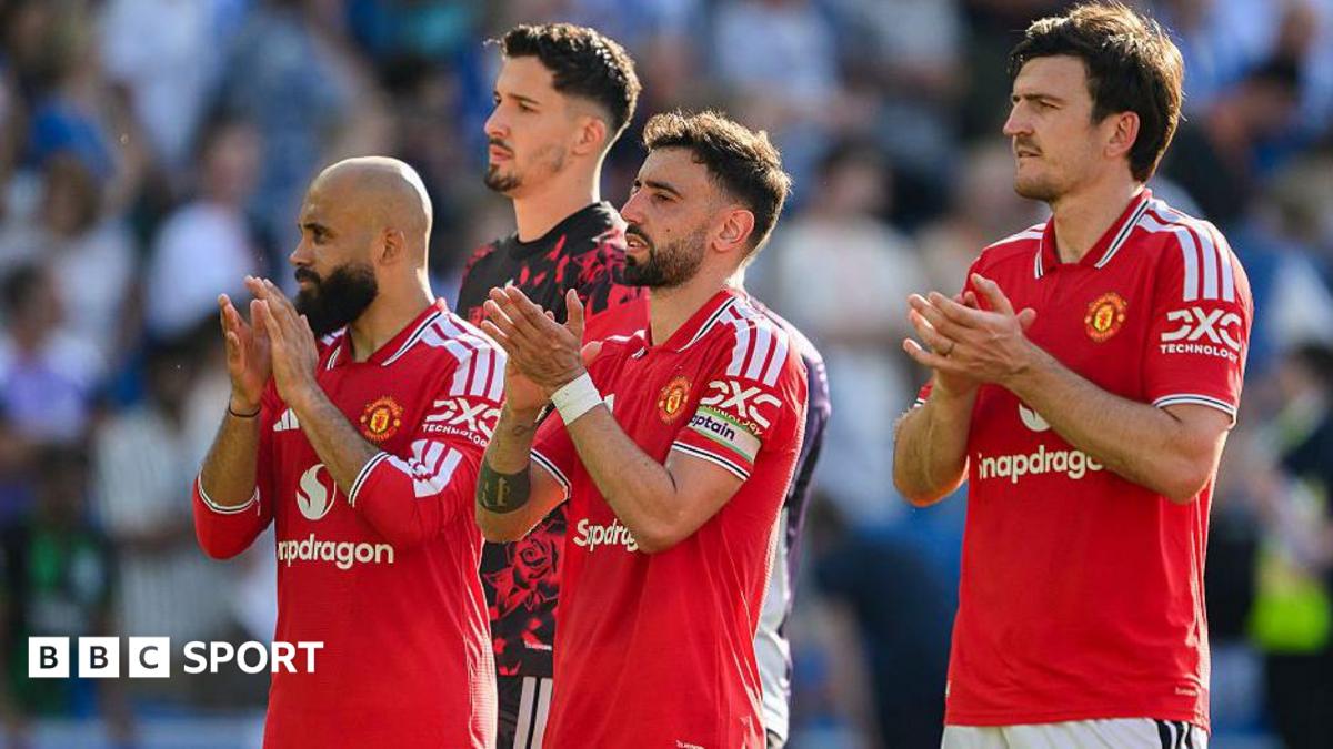 Manchester United players in red shirt, including Bruno Fernandes (centre) and Harry Maguire (right), applaud the crowd.