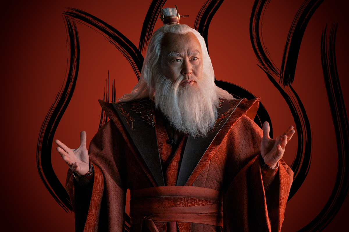 C.S. Lee as Avatar Roku with long white hair and beard, dressed in ornate red robes, stands with arms raised before a stylized flame emblem on a deep red background, suggesting an important, regal, or mystical setting.