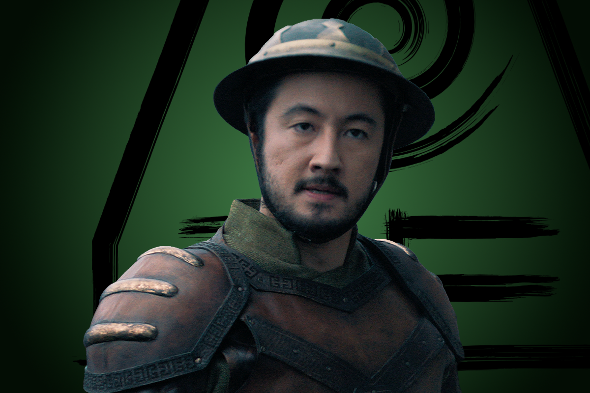 Gabriel Prevost-Takahashi as Lieutenant Khettry armor and a helmet stands in front of a green background with black geometric designs, looking directly at the camera with a serious expression.