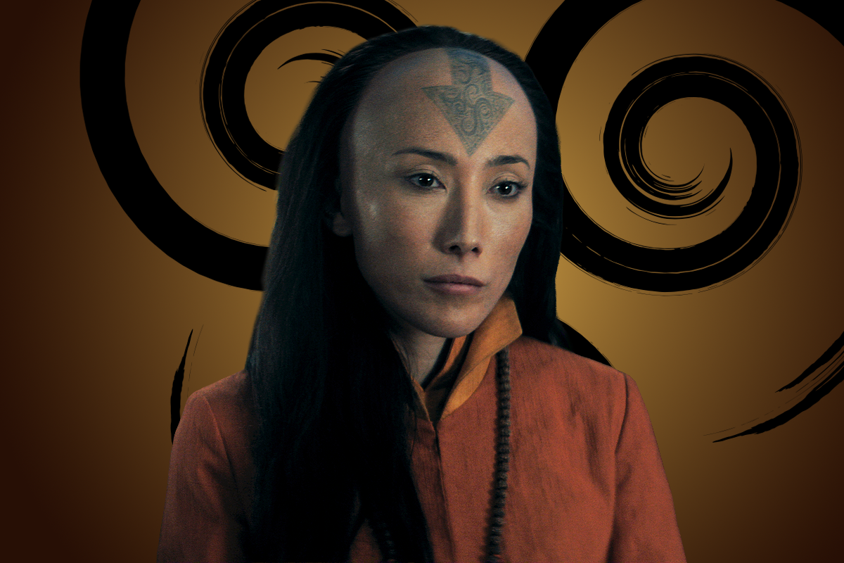Dichen Lachman as Avatar Yangchen with a prominent tattoo on their forehead, wearing an orange robe with black beads, stands in front of a stylized, swirling brown and black background, suggesting a mystical or fantasy setting.