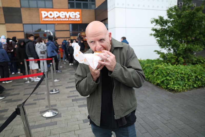 Conor Pope tastes a Popeyes chicken burger which some customers in Blanchardstown queued overnight for. Picture: Enda O'Dowd
