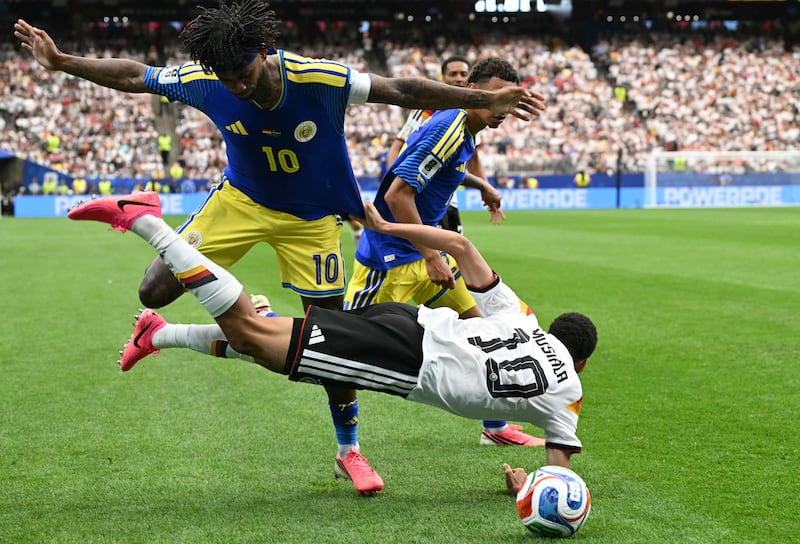 Jamal Musiala falls in a challenge with Leandro Bacuna during Germany's 7-1 World Cup win over Curaçao. Photograph: Ronaldo Schemidt/AFP via Getty Images