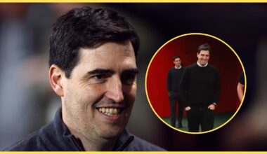 Liverpool manager Andoni Iraola smiles next to picture of him on the AXA training centre pitch.
