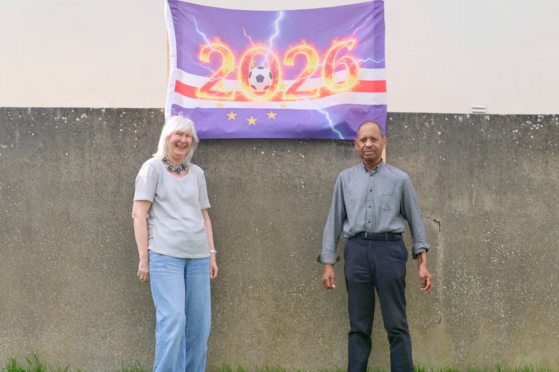Judy and Carlos Lopez outside their house with the Cape Verde World Cup flag.