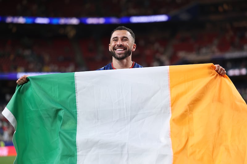 Pico Lopes celebrates with an Irish flag after Cape Verde's draw with Saudi Arabia saw them seal a place in the last 32 of the World Cup.  Photograph: Francois Nel/Getty Images