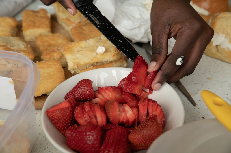 Aulbright Nyih prepares strawberries for her event. Photo: Natalia Campos/ The Irish Times