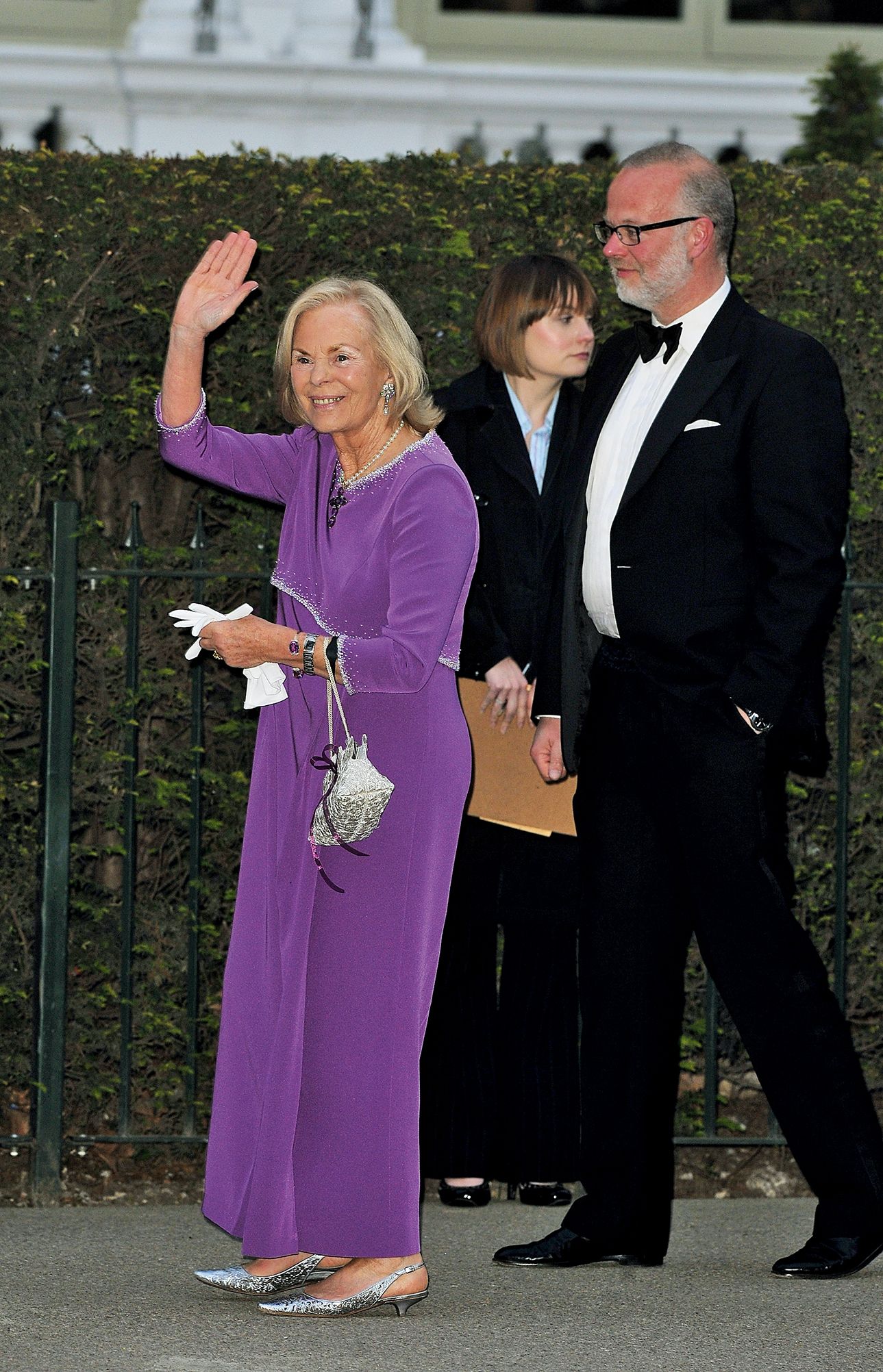 Image may contain Person Clothing Formal Wear Suit Adult Accessories Bag Handbag Glove Photobombing and Coat