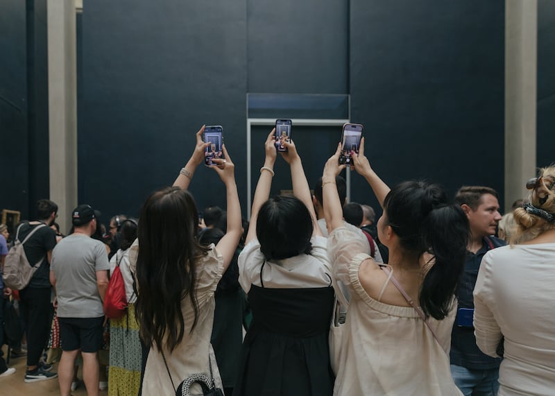 Visitors angle for a photograph of the Mona Lisa at the Louvre. Photograph: Andrea Mantovani/The New York Times
                      