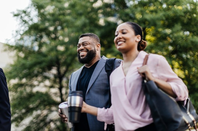Mature businessman laughing while walking with female colleague