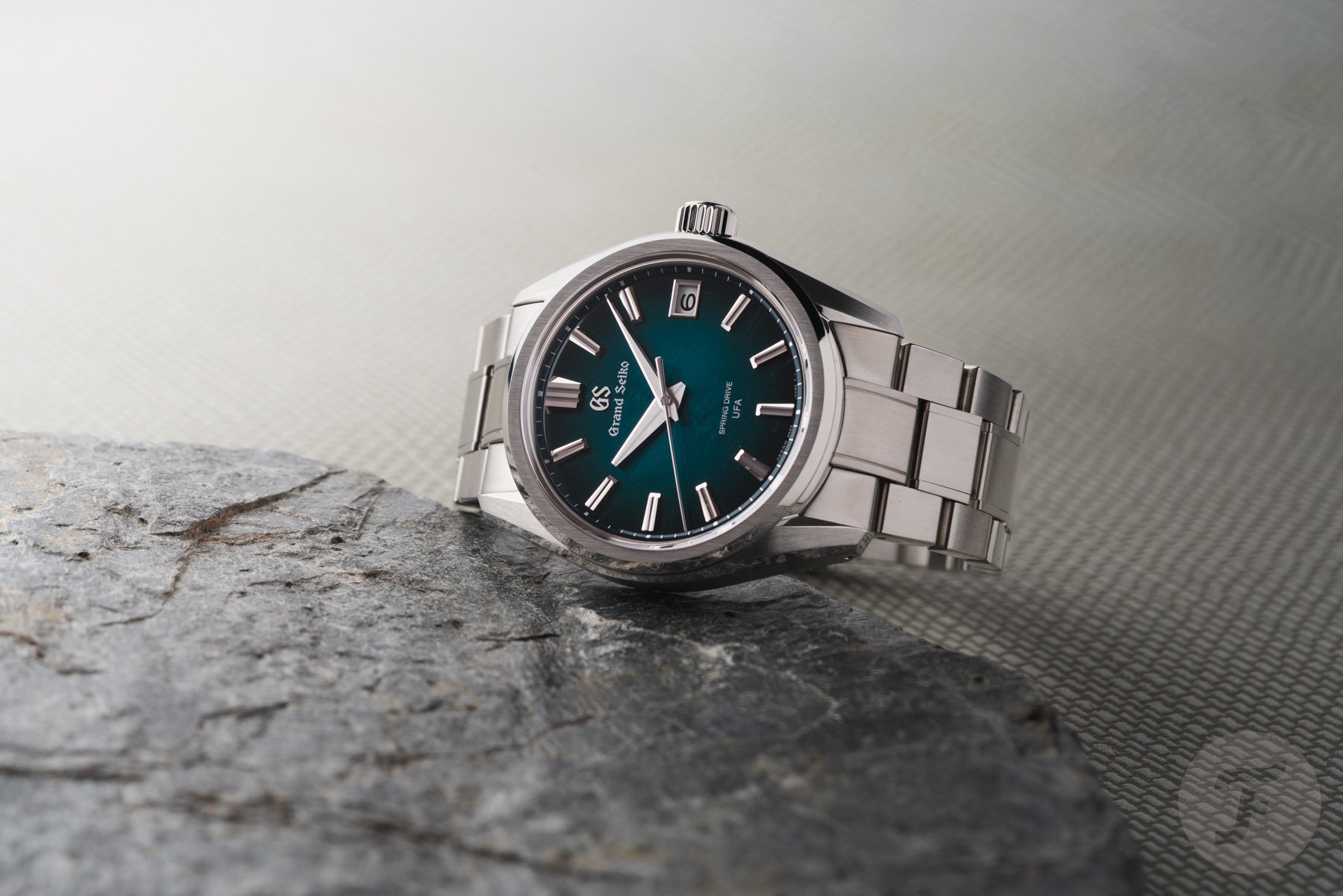Grand Seiko Evolution 9 Spring Drive U.F.A. SLGB011 on its side, crown up, on rock