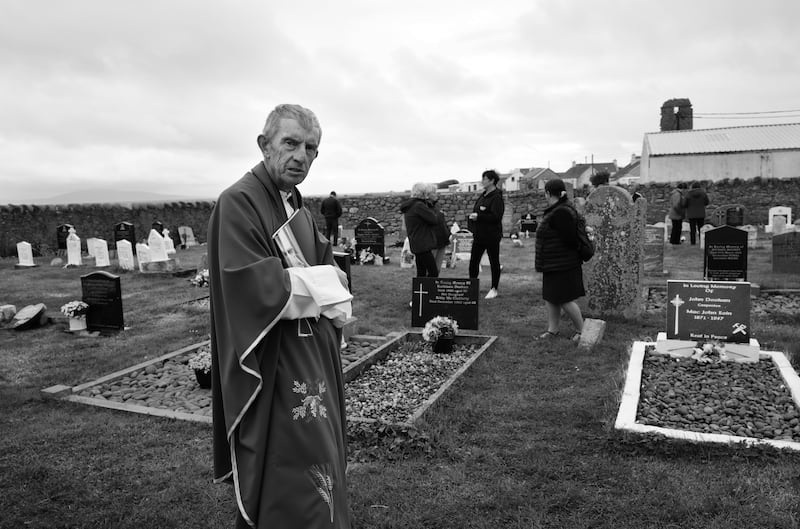 Fr Boyle blessing graves of Tory Island parishioners in 2023. Photograph: Eric Luke