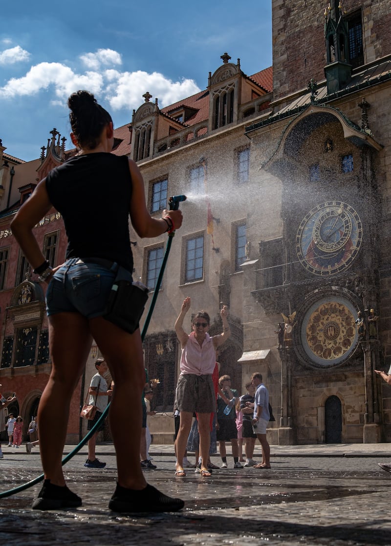 A restaurant staff member sprays people with water to help cool them at the Old Town Square in Prague, Czech Republic on Saturday. Photograph: Fadi Yousef/EPA