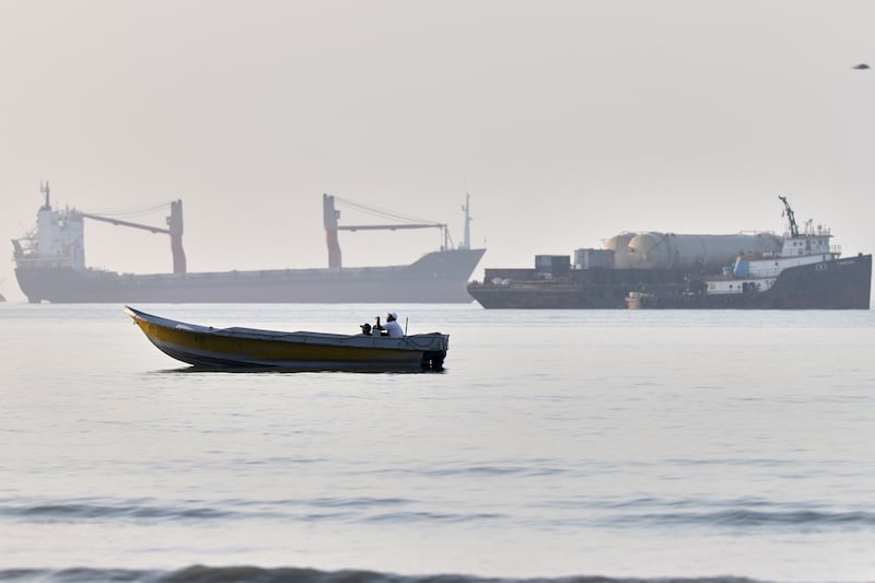 A small boat moves along the shoreline where larger ships are all anchored in the Strait of Hormuz off Bandar Abbas, Iran. Photograph: Amirhosein Khorgooi/ISNA/AP