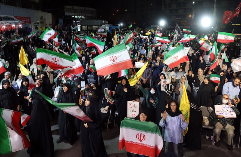 People wave Iranian and Hizbullah flags during a rally following Iran's attack on Israel, at Valiasr square in Tehran on Sunday. Photograph: Abedin Taherkenareh/EPA