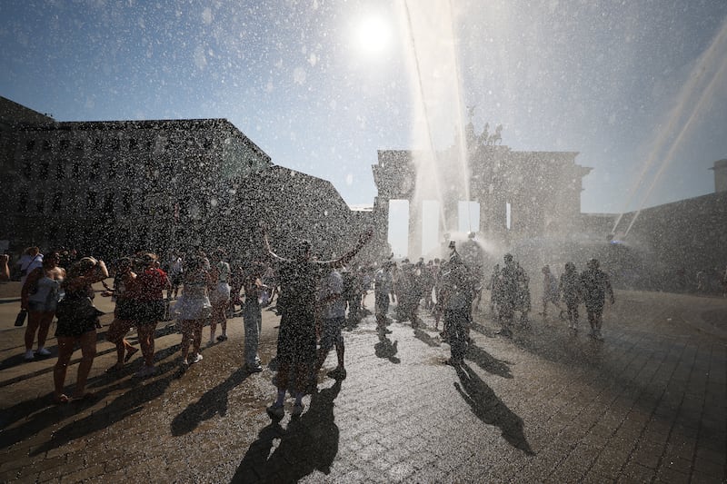 Police water canon sprays tourists at the Brandenburg Gate during a heat wave in Berlin, Germany, on Saturday. Photograph: Krisztian Bocsi/Bloomberg