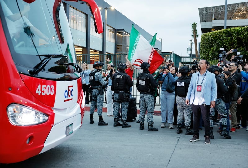 Soccer fans wave as the Iranian national soccer team departs on a bus from Tijuana International Airport. Photograph: Mario Tama/Getty