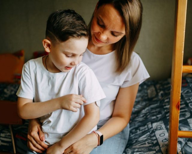 A mother helps her child monitor his blood glucose