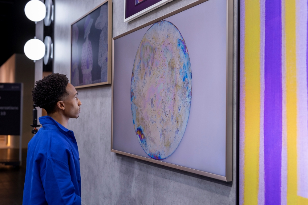 ▲ A visitor takes in the vibrant work of Raphael Hefti on display.